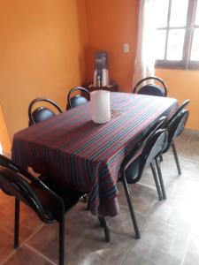 una mesa con sillas y un mantel a rayas. en Hosteria M.G en Tilcara