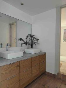 a bathroom with two sinks and a large mirror at Vistas de Ensueño en Acapulco in Acapulco