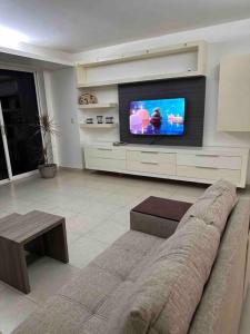 a living room with a couch and a flat screen tv at Vistas de Ensueño en Acapulco in Acapulco