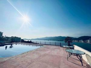 a swimming pool with a table and a view of the water at Vistas de Ensueño en Acapulco in Acapulco