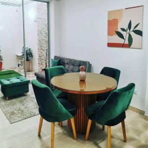ein Wohnzimmer mit einem Tisch und grünen Stühlen in der Unterkunft Nuevo y lindo apartamento in Yopal