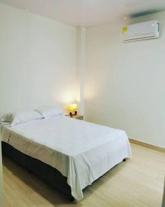 Un dormitorio con una cama con una manta blanca. en Nuevo y lindo apartamento, en Yopal