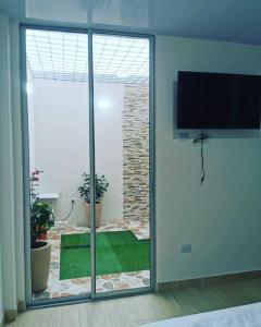 Pokój z przesuwnymi szklanymi drzwiami i widokiem na ogród w obiekcie Nuevo y lindo apartamento w mieście Yopal