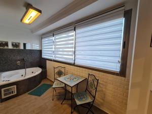 a bathroom with a table and two chairs and a tub at Blue moon apartment in Eilat