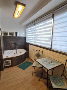a bathroom with a tub and a table and a table and chairs at Blue moon apartment in Eilat