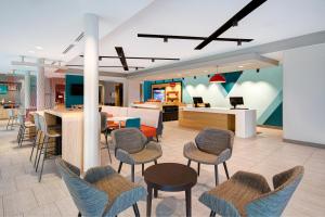 a lobby with chairs and tables and a dining area at avid hotels Fort Mill - Amusement Park, an IHG Hotel in Fort Mill