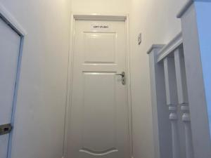 a white door with a sign on it in a hallway at Remarkable 1-Bed Studio Apartment in Redbridge in Ilford