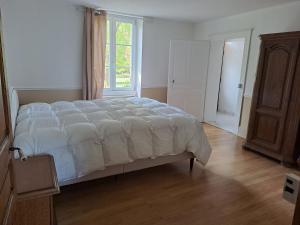 a bedroom with a large bed with a window at Maison du parc 