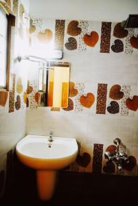 baño con lavabo y una vela en la pared en Fortis Rooms en Kochi