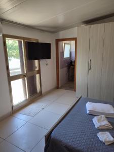 Schlafzimmer mit einem Bett und einem Flachbild-TV in der Unterkunft Marina Holidays in Camemi