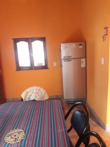 een keuken met een koelkast en een stoel in een kamer bij Hosteria M.G in Tilcara