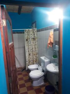 Baño azul con aseo y lavamanos en Hosteria M.G en Tilcara