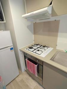 a kitchen with a stove top oven next to a refrigerator at Paisible in Agde