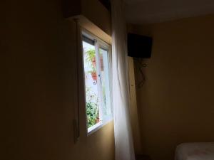 una puerta abierta con ventana y TV en HOSTAL COSTA SOL en Castell de Ferro