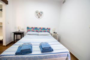 モトリルにあるRentitSpain Carrera del Mar, 17 Apartamentoのベッドルーム1室(青いタオル付きのベッド1台付)
