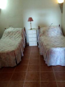 ein Schlafzimmer mit 2 Betten und eine Kommode mit einer Lampe in der Unterkunft Cuevas Alia in Castilléjar