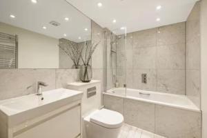 e bagno con lavandino, servizi igienici e vasca. di Well-Positioned Studio Flat a Londra