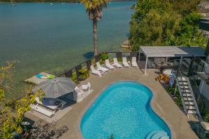 an overhead view of a swimming pool with chairs and an umbrella at Oceans 88 Whitianga Coastal Suites in Whitianga