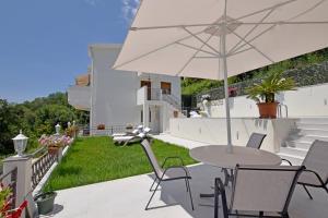 a patio with a table and an umbrella at Vila Djordjevic in Herceg-Novi