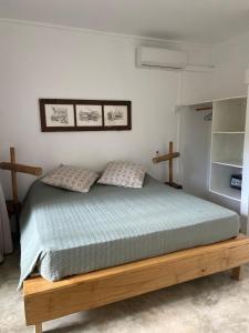 a bedroom with a wooden bed with two pillows at Otium in Coteau Raffin