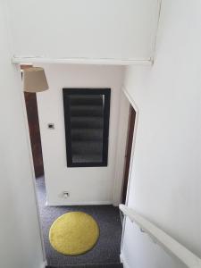 a small room with a yellow rug and a window at 4 mereside walk in Manchester +1 photo