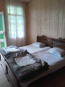 een slaapkamer met 2 bedden in een kamer met een raam bij Guest House Guliada in Gordi