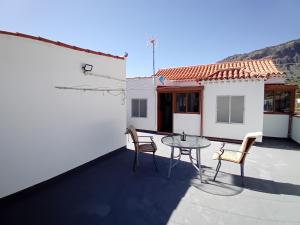 a patio with a table and chairs and a house at Victoria 1 in Tejeda