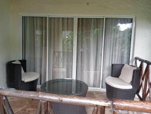 einen Glastisch und Stühle vor einem Fenster in der Unterkunft Oasis Retreat in Diani Beach