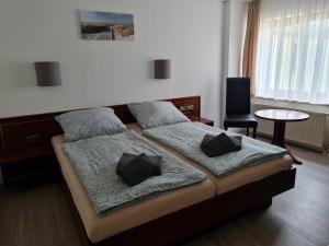 a bedroom with a bed with two pillows on it at Traditionshotel Goldener Löwe in Zeulenroda