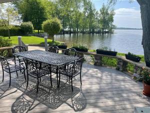 einen Tisch und Stühle auf einer Terrasse neben dem Wasser in der Unterkunft Paradise Retreat in Chazy