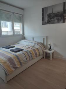 a bedroom with a bed and a table with a lamp at Studio Paris Sud à côté du métro in Villejuif