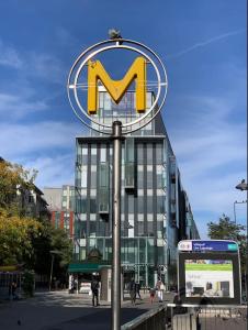 um grande sinal M em frente a um edifício em Studio Paris Sud à côté du métro em Villejuif
