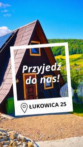 ein Bild eines Hauses mit einem Schild darauf in der Unterkunft Wzgórze w Cieniu Lasu in Łukowica