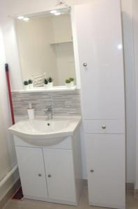 a white bathroom with a sink and a mirror at Studio Paris Sud à côté du métro in Villejuif
