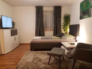 Sala de estar con cama, sofá y mesa en Ferienwohnungen Klimbacher, en Sankt Andrä