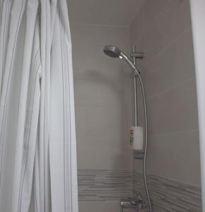 uma cabeça de chuveiro na casa de banho com uma cortina de chuveiro em Studio Paris Sud à côté du métro em Villejuif