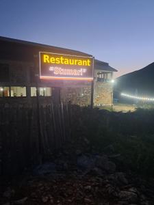 a sign for a restaurant in front of a building at Ushguli Hotel Riho in Ushguli