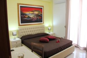 a bedroom with a bed with a painting on the wall at B&B Trapani Bedda in Paceco