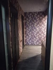 a hallway with a purple wall with a patterned wall at Уютная 2х комнатная квартира 40 лет in Pavlohrad