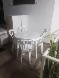 einen weißen Tisch und Stühle in einem Zimmer mit Pflanze in der Unterkunft דירת אירוח ימית in Bet Scheʼan
