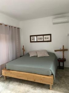 1 dormitorio con 1 cama con marco de madera en Otium en Coteau Raffin