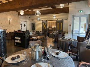 a restaurant with tables and chairs in a room at Hôtel-Restaurant-Chambre Insolite Spa - Le XII de Luynes in Luynes