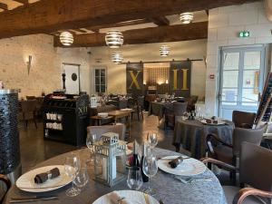 um restaurante com mesas e cadeiras num quarto em Hôtel-Restaurant-Chambre Insolite Spa - Le XII de Luynes em Luynes