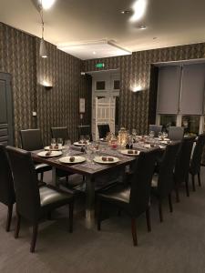 ein großes Esszimmer mit einem langen Tisch und Stühlen in der Unterkunft Hôtel-Restaurant-Chambre Insolite Spa - Le XII de Luynes in Luynes