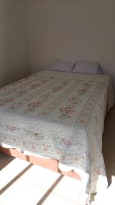 een bed in een kamer met een deken erop bij Apto Cenário de Montanha in Petrópolis