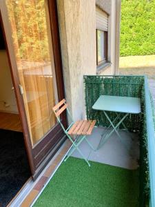 une table et une chaise assises sur une terrasse couverte dans l'établissement Agréable appartement 2 pieces a forbach avec Garage fermé - check in autonome, à Forbach