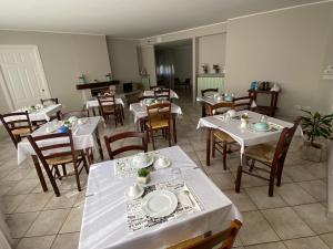 un restaurante con mesas y sillas con platos blancos. en ATLAS en Serravalle Sesia