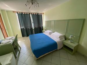 Un dormitorio con una cama azul y una ventana en ATLAS en Serravalle Sesia
