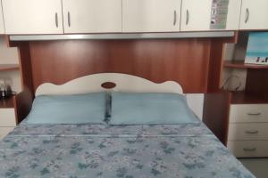 um quarto com uma cama e uma cabeceira em madeira em Appartamento Orchidea em Rimini