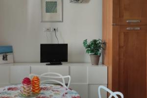 um quarto com uma mesa com uma televisão e um prato de comida em Appartamento Orchidea em Rimini